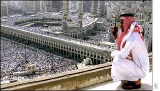 A Saudi security man looks on from a roof top as Muslim pilgrims gather inside and outside the grounds of the holy Kaaba 
