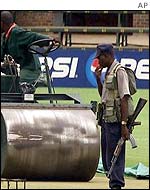 Armed policeman on the cricket pitch
