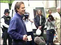 Prime Minister Tony Blair, paternal mug in hand, relaxes in front of the media 