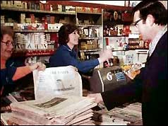 Man buys copy of new Times edition at a newsagent's