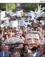 Caricatures of John Howard and George W Bush are carried by protestors