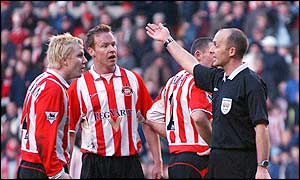 Sunderland players are furious as referee Mike Dean orders that Tommy Smith's second half spot-kick must be taken again after goalkeeper Thomas Sorensen saved his first effort