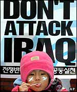 Young South Korean girl blows bubble in front of anti-war poster 