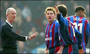 Referee Dermot Gallacher is surrounded by protesting Crystal Palace players