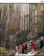 South Korean tourists stand on a cliff bearing a slogan praising former North Korean leader Kim Il-sung 