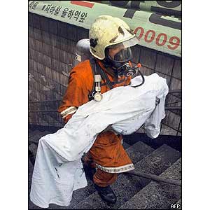 A firefighter carries a body from the subway