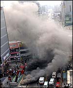 Smoke pours from ventilation shafts after the Daegu arson