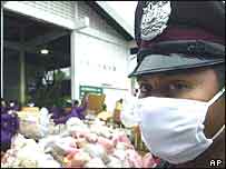 A Thai policeman stands next to a haul of methamphetamine haul in Ayutthaya province
