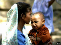 A Muslim woman and child in a refugee camp after the riots last year