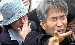 Weeping man reaches out at sight of burned carriages put on display