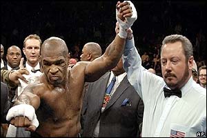 Mike Tyson reacts to the crowd as refree Bill Clancy holds his arm up as the winner