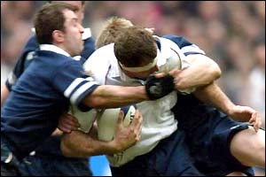 Olivier Magne is dragged down by the Scottish defence