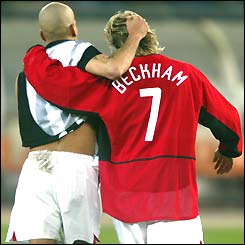 Manchester United's Juan Sebastian Veron ruffles team-mate David Beckham's hair as the pair leave the pitch in Turin