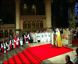 Dr Williams stands before the Chair of St Augustine