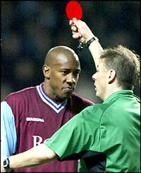 Aston Villa's Dion Dublin is shown the red card after his fracas with Robbie Savage