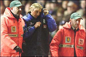 Birmingham's controversial midfielder Robbie Savage is escorted from the stadium after being substituted in a bid to calm things down on and off the pitch