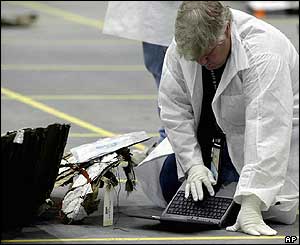 A Nasa technician uses a computer to check a piece of debris