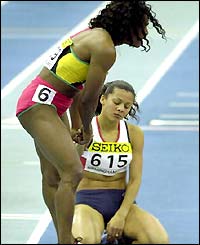 800m gold medal winner Maria Mutola hauls a distraught Jo Fenn to her feet