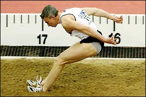 Jonathan Edwards leaps into the sand during the triple jump final