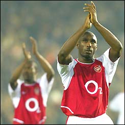 Lauren and Sol Campbell applaud the Arsenal fans after their defeat in Valencia