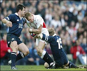 Kenny Logan and Glenn Metcalfe stop Lewsey in his tracks