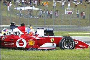 Michael Schumacher's Ferrari rolls across the grass