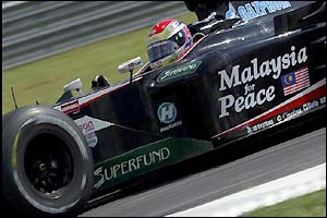 Minardi's Justin Wilson and the teams sponsor logo 'Malaysia for Peace' 