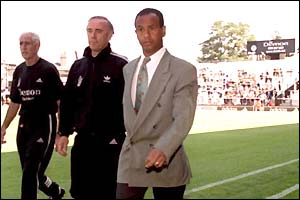 Assistant Christian Damiano walks with Jean Tigana to the dugout