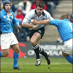 Scotland's Kenny Logan evades the challenge of Andrea Lo Cicero