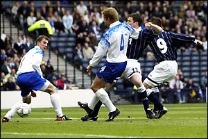 Kenny Miller scores for Scotland under pressure from Iceland defenders