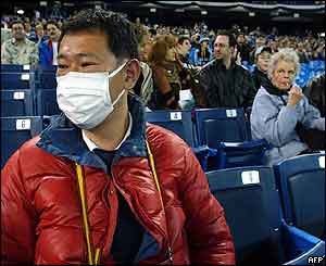 A baseball fan wears a mask to protect against SARS in Toronto's Skydome stadium.