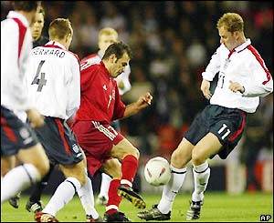 Turkey's Buruk Okan tries to find a way through the England midfield