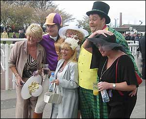 Race fans dressed in fancy dress mix with smartly dressed ladies during racing at Aintree