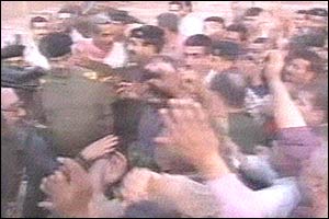 Iraqi TV shows Saddam Hussein surrounded by a crowd of cheering Iraqis