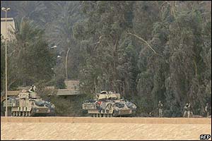 American troops disembark from tanks which have entered Baghdad