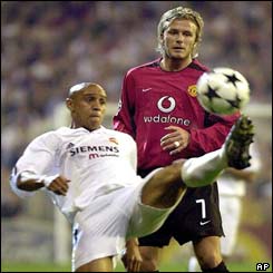 Real Madrid's Roberto Carlos controls the ball in front of Manchester United's David Beckham 