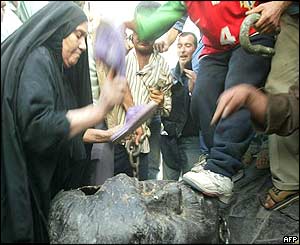 Iraqis attacking the remains of the Saddam statue