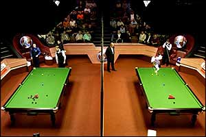 A screen splits the two tables in earky rounds of the tournament