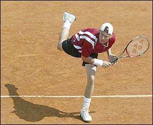 Australia's Lleyton Hewitt hits a serve to America's Brian Vahaly 