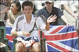 Tim Henman pats his racket during a break