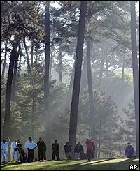 Arnold Palmer is obscured by the morning mist as he plays the 15th