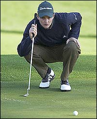 Justin Rose lines up a putt on the second green