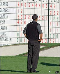 Tiger Woods looks at the leaderboard but just makes the cut of five over par