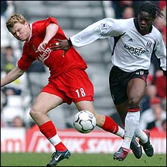 Liverpool's John Arne Riise takes the ball away from Fulham's Louis Saha