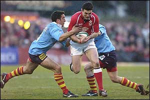 Llanelli's Stephen Jones is tackled by Perpignan's Gregory Le Corvec 
