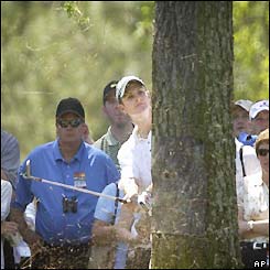 Justin Rose hits a shot from behind a tree, finishing the tournament with a score of nine over