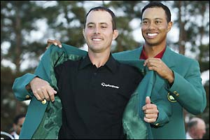 2002 champion Tiger Woods helps Mike Weir don his Green Jacket 