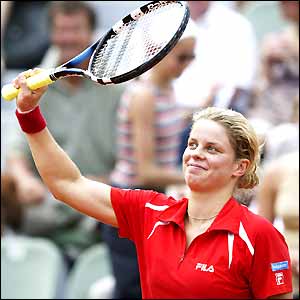 Kim Clijsters raises her racquet to salute victory