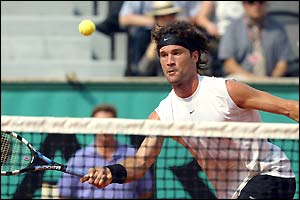 Carlos Moya returns a shot to Juan Ignacio Chela