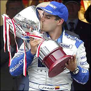 Juan Pablo Montoya plants a kiss on the winners trophy